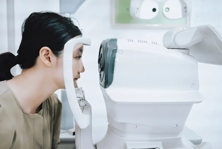 視力検査機器をのぞき込み、眼科検査を受けている女性。