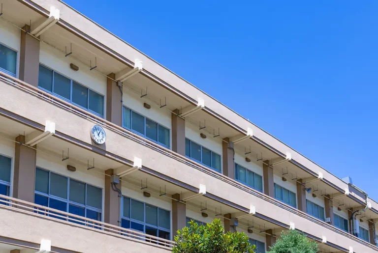 青空の下に建つ学校校舎の外観。