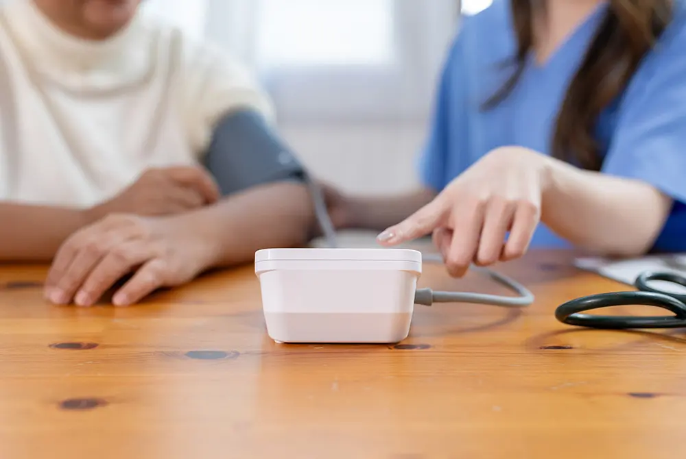 医療従事者が血圧計の使い方を指差して説明している様子。