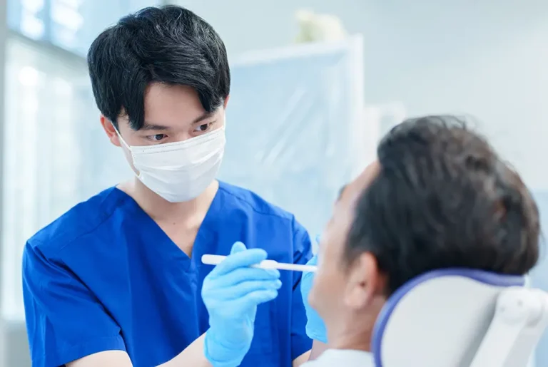 歯科医師が患者の口腔内を診察している様子。