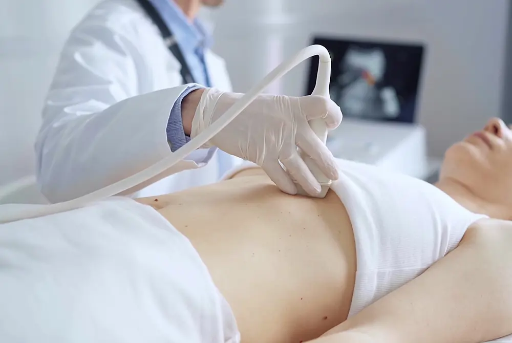 医師が女性の乳房に超音波プローブを当てて検査している様子。