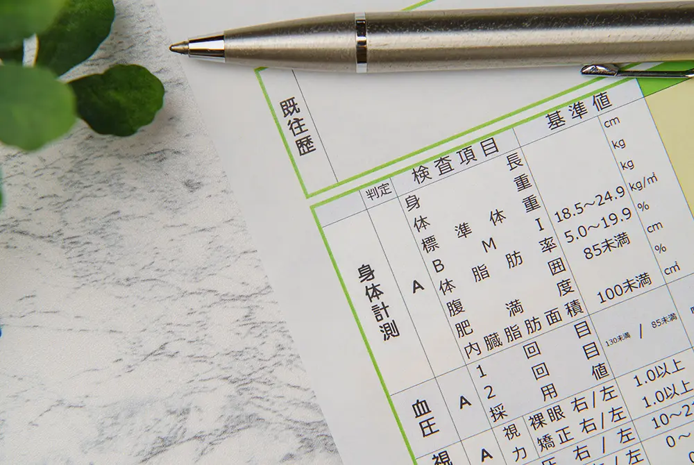 健康診断の結果票とペンが置かれた様子。