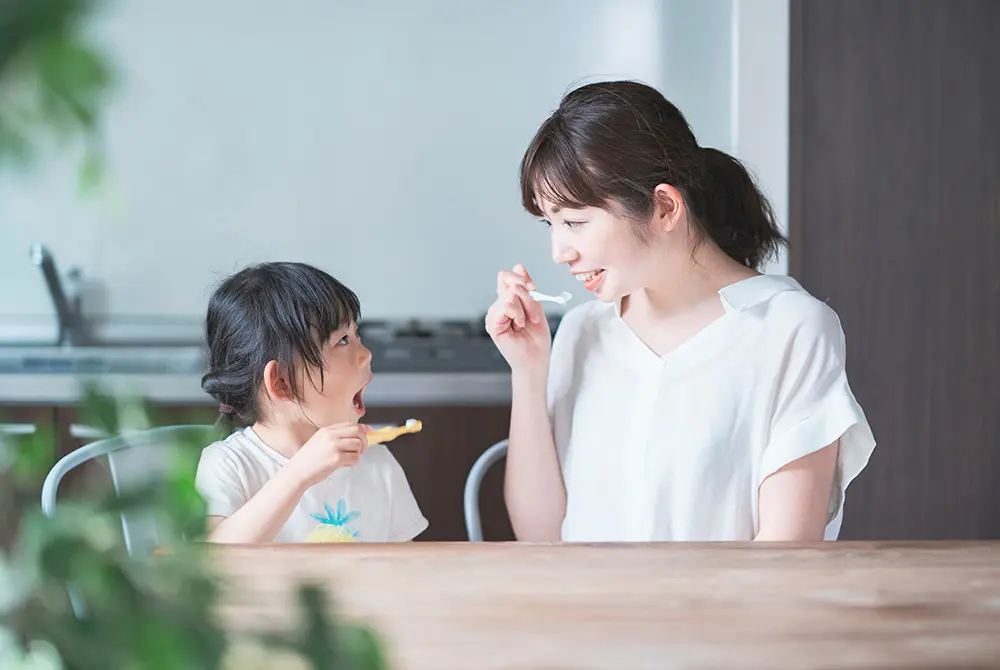 母親と子どもが並んで歯みがきをしている様子。
