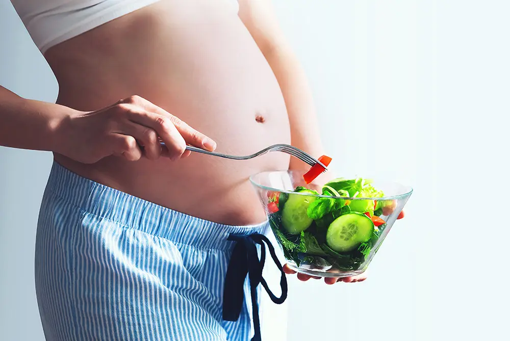 妊娠中の女性がサラダを食べている様子