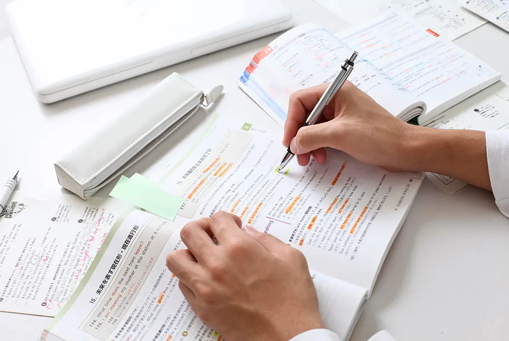 参考書に線を引きながら勉強している手元