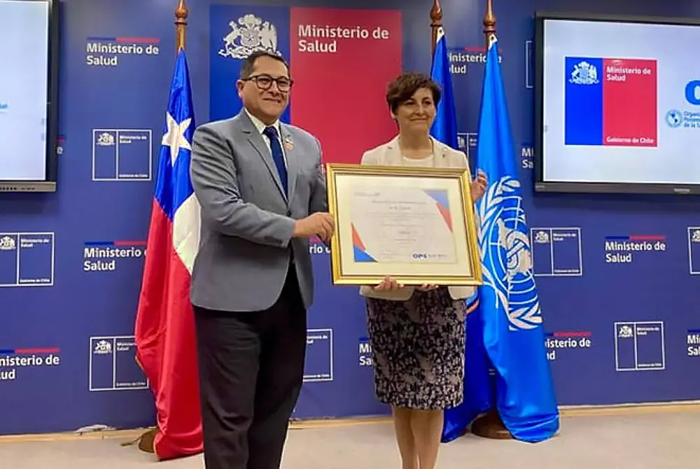 ハンセン病排除認定の式典で証書を掲げるチリ保健相とWHO関係者