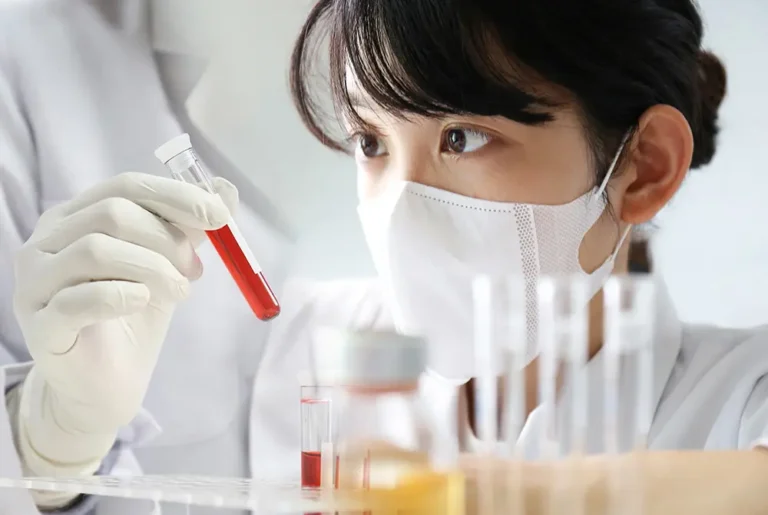 血液の入った試験管を確認する研究者