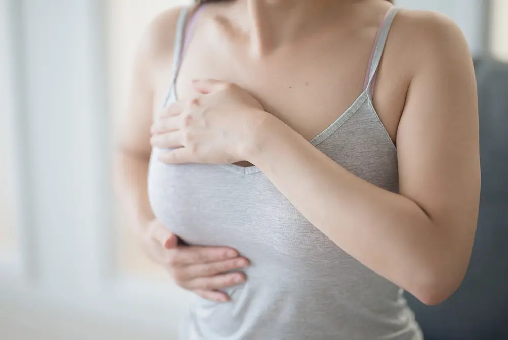 胸のしこりを気にして手を当てる女性