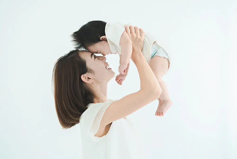 赤ちゃんを抱き上げて見つめ合う母親