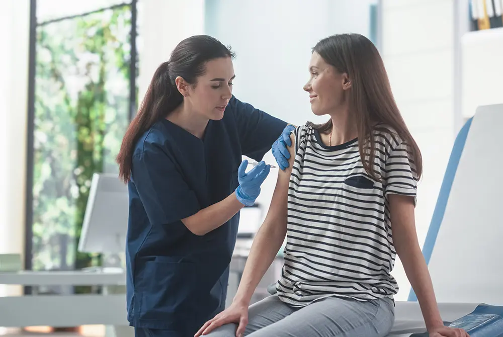 医療従事者が女性の上腕に注射を行う様子