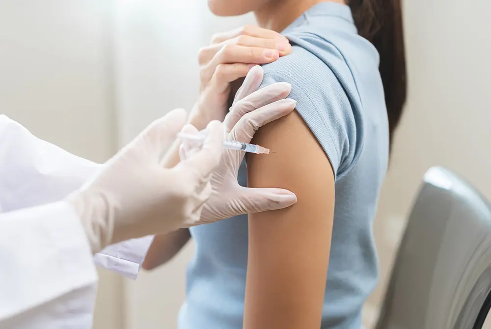 腕にワクチン注射を受けている女性