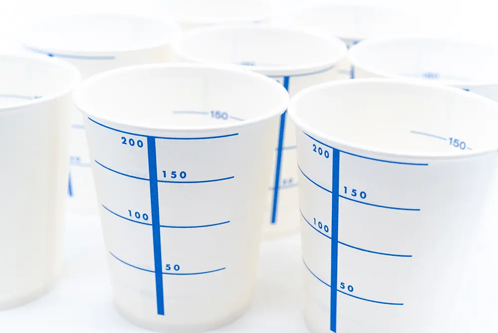 目盛り付きの採尿用カップが複数並べられている様子