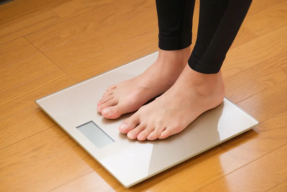 体重計の上に両足を乗せて測定している様子