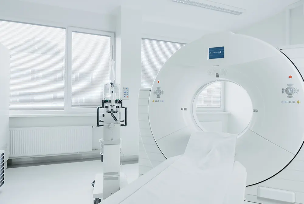 白い検査室に設置された大型の画像診断装置と検査台。