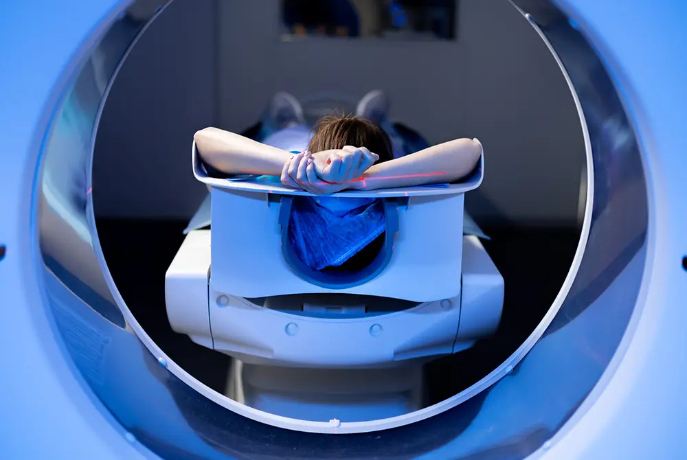大型の画像診断装置の中で、検査台に横たわって検査を受ける患者。