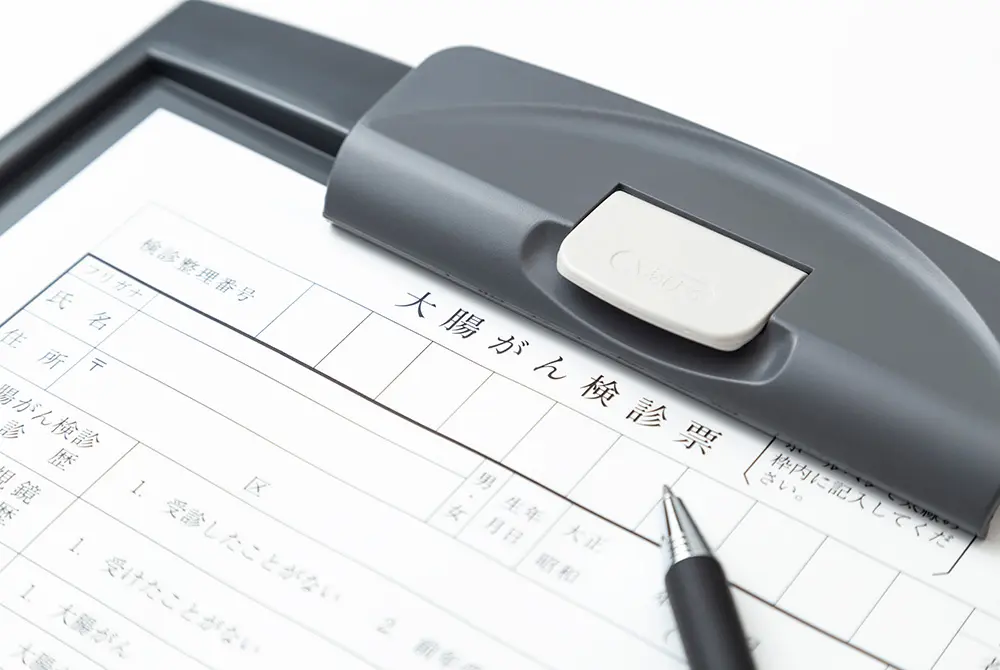 クリップボードに挟まれた大腸がん検診票と、記入用のペン。