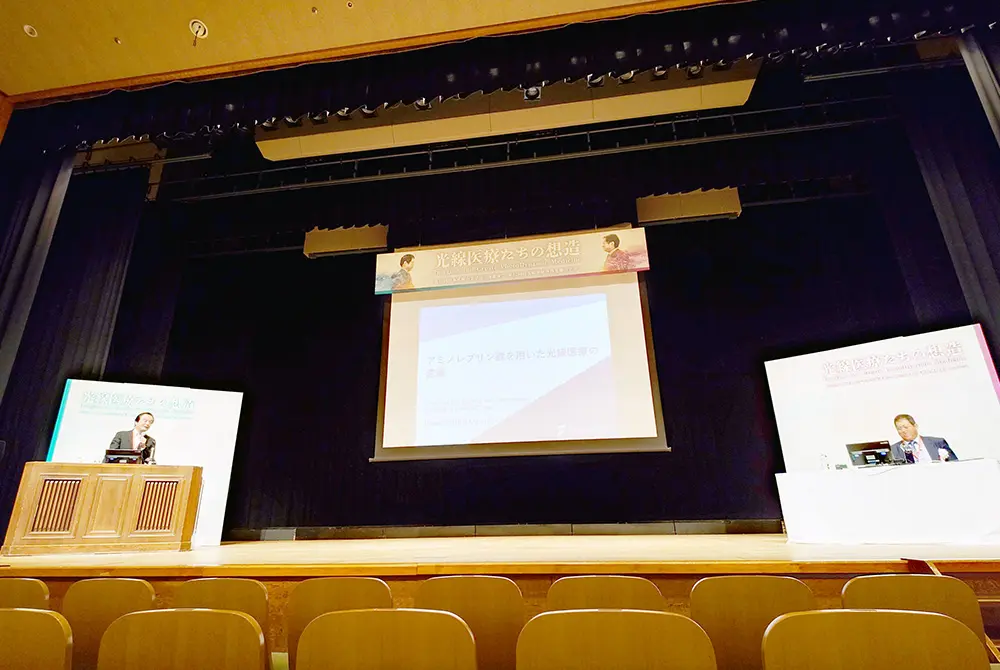 第36回日本光線力学学会学術講演会で、演者の小倉俊一郎氏と座長の井上啓史氏が登壇している様子。