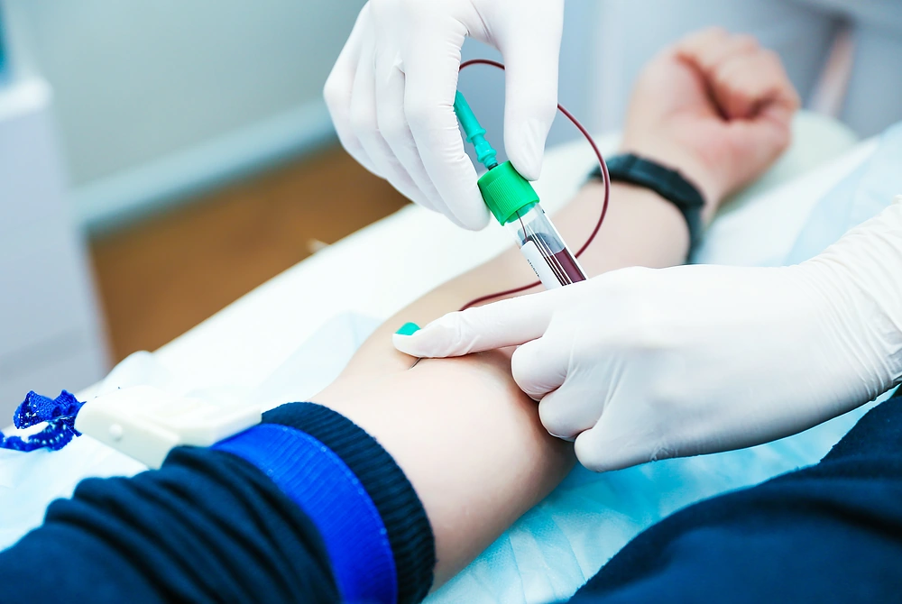 医療従事者が患者の腕から採血している様子。