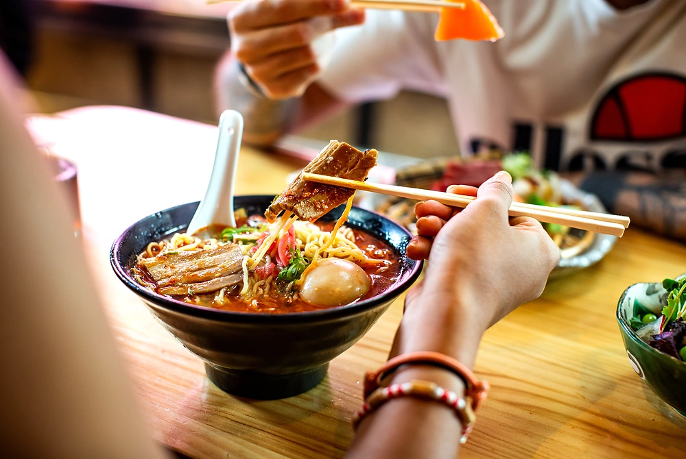 ラーメンを箸で食べている食事中の様子。