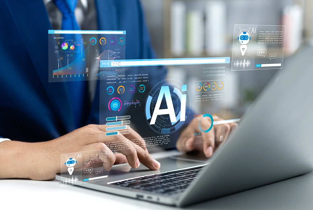 ノートパソコンを操作する人の前に、AIやデータ解析を示す画面が重なって表示されている様子。