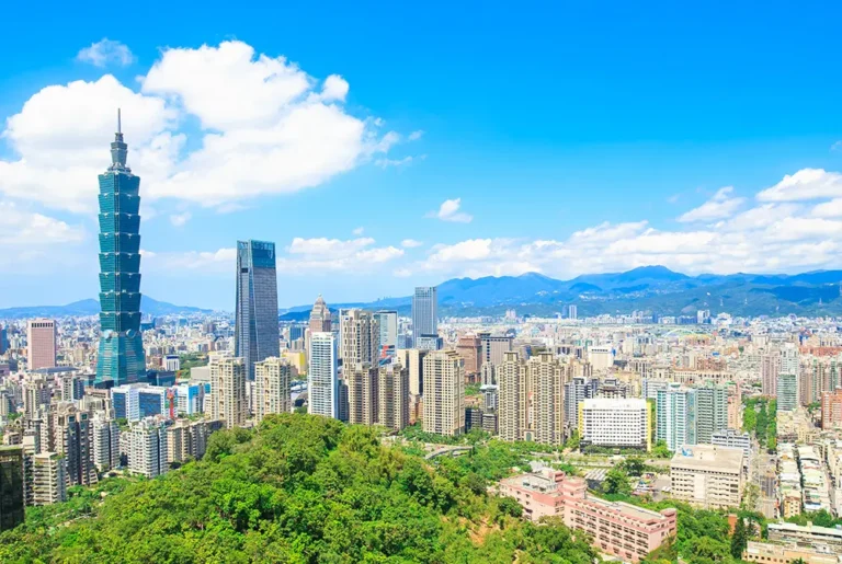 青空の下に広がる台北市街と、台北101を含む高層ビル群。