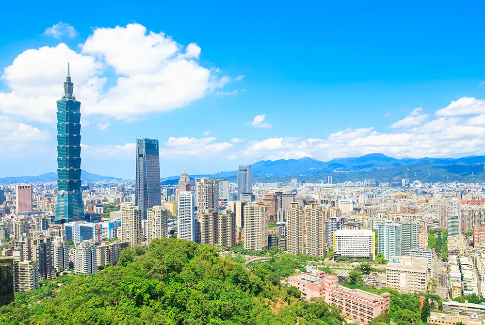青空の下に広がる台北市街と、台北101を含む高層ビル群。