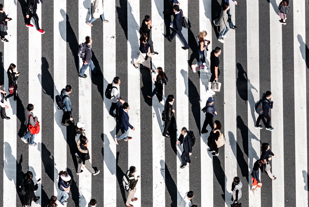 多くの人が横断歩道を行き交っている様子を上から見た写真。