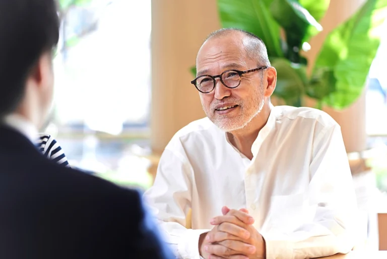 高齢男性が、向かい合う相手と話をしている様子。