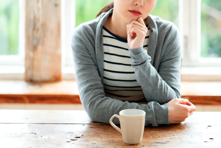 窓際のテーブルで、検診について考えているような女性。