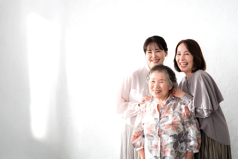 3世代の女性が並んで笑顔を見せている。