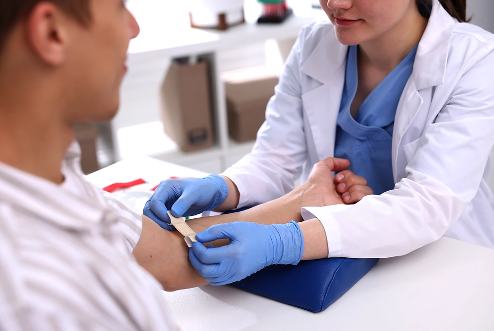 医療従事者が患者の腕から採血している様子。