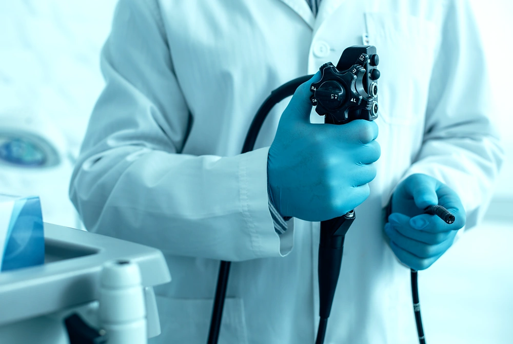 医療従事者が内視鏡を手に持ち、検査に備えている様子。