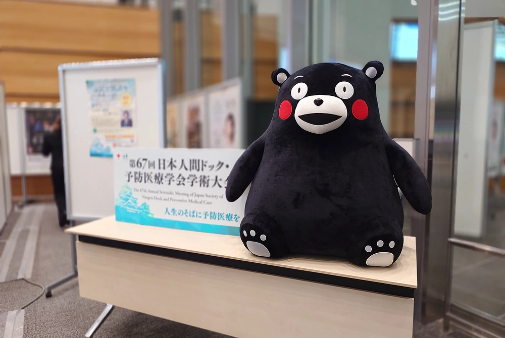 第67回日本人間ドック・予防医療学会学術大会の会場受付付近に置かれた案内表示とくまモンのぬいぐるみ。