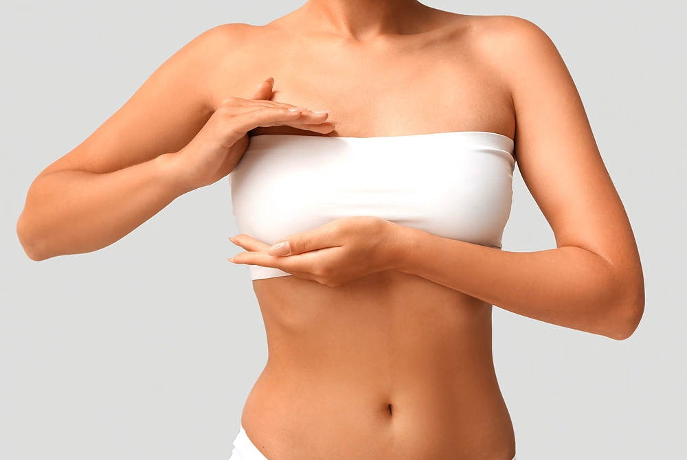 乳房の横に手を当てて確認する女性。