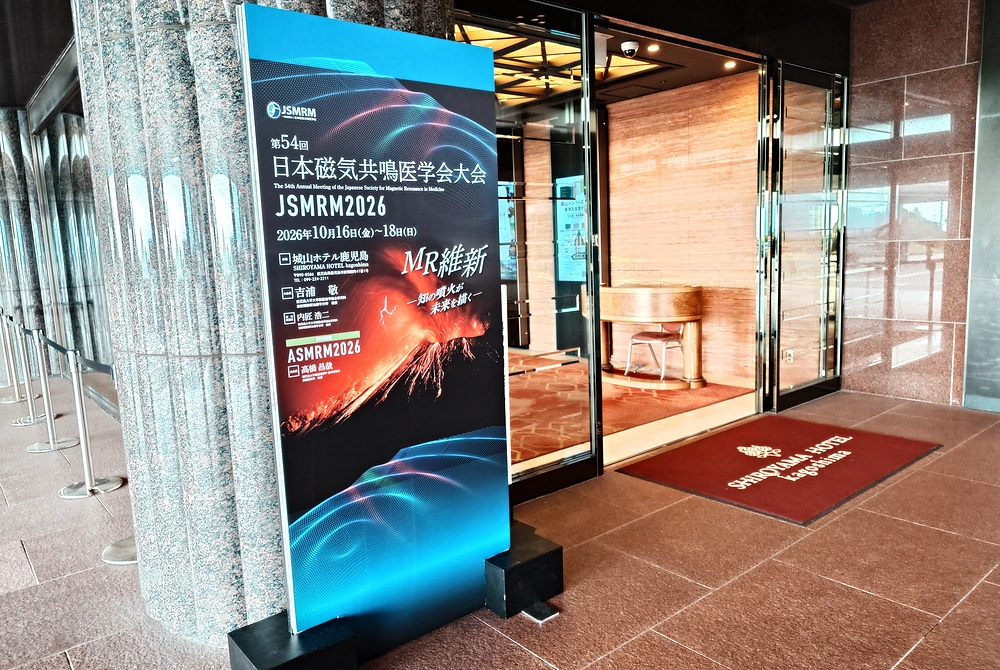 鹿児島市の城山ホテル鹿児島で開催された第54回日本磁気共鳴医学会大会の会場入口。大会名や開催日程が記された案内看板が設置されている。