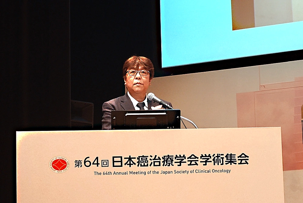 第64回日本癌治療学会学術集会の演台で講演する、日本癌治療学会理事長の吉野孝之氏。