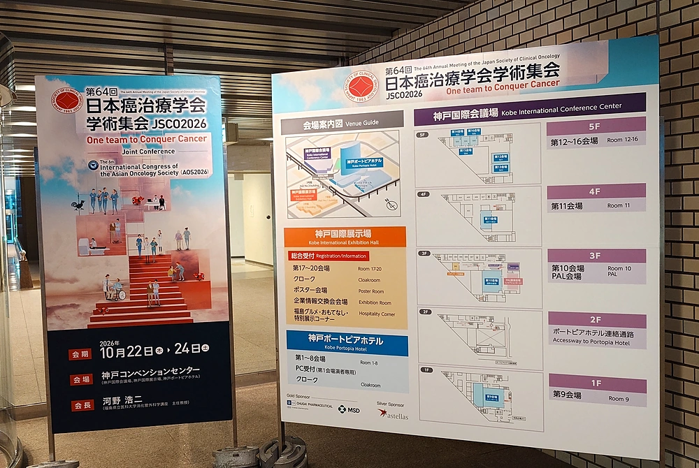 第64回日本癌治療学会学術集会の会場案内看板。大会の開催日程とテーマ、神戸国際会議場などの会場配置図が表示されている。