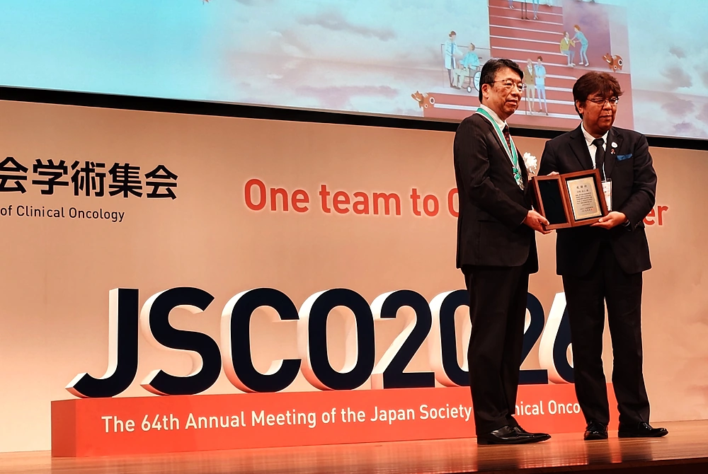 第64回日本癌治療学会学術集会の壇上で、記念の盾を手に並ぶ河野浩二会長（左）と日本癌治療学会の吉野孝之理事長（右）。